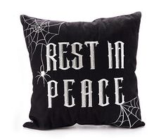 a black pillow with the words rest in peace printed on it and spider webs