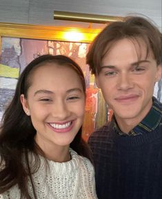 a young man and woman are smiling for the camera while standing next to each other