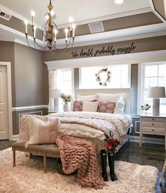 a bedroom with a large bed, chandelier and rugs on the floor