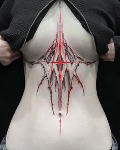 a woman's back with red and black designs on it, including an inverted design