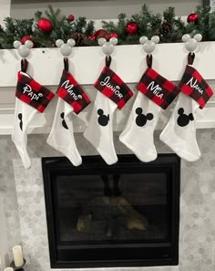 christmas stockings hanging from a fireplace mantel decorated with mickey mouse and minnie mouse stocking