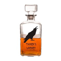 a glass bottle with a black bird on it's side and the words nevermore in orange ink