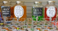 three glass jars with labels on them are sitting on a table next to candy and candies