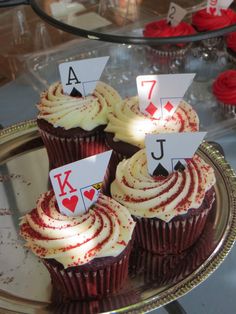 cupcakes with cards on them sitting on a tray