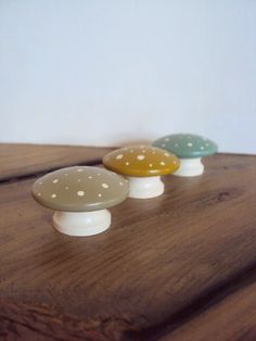 three small mushrooms sitting on top of a wooden table