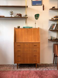 a wooden dresser sitting in the corner of a room with shelves on either side and an animal figurine on top