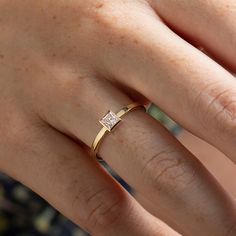 a woman's hand with a diamond ring on top of her finger, showing the band