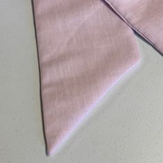 a pink tie laying on top of a white table