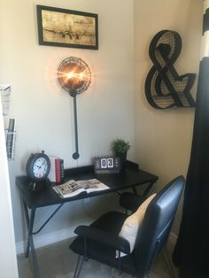 a desk with a lamp and some pictures on the wall