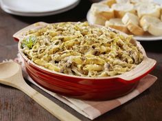 a casserole dish filled with macaroni and cheese on a wooden table