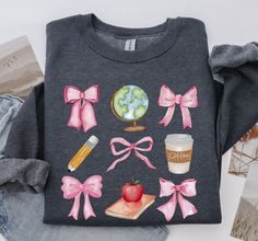 This Coquette Teacher Sweatshirt is now available for purchase, as back to school season approaches. It's very preppy and girly. Made with colorful hand painted watercolor classroom elements, stacked in a 3x3 collage with pink bows. Coquette bows are so popular this year! Highly requested by my customers! This is the perfect first day of school tee, perfect as a gift for teachers. Show your appreciation with this trending font combo. The vintage designs marries very well with the unique colors of this Crewneck, making it a classic. Let's see some of the more technical feature of the Sweater: -Ink penetrates deep into fibers and is more durable than vinyl or screen-printed designs. No cracks! -Vibrant Colors  -Environmentally friendly water-based, biodegradable and non-toxic inks - Made usi Preppy Pink Tops For School, Preppy Pink Top For School, Cute Pink Sweatshirt For School, Pink Casual School Sweatshirt, Casual Pink Sweatshirt For School, Cute Cotton Sweatshirt For School, Pink Graphic Print Sweatshirt For School, Watercolor Classroom, Bows Coquette