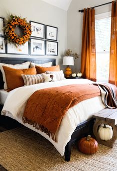 a bedroom with orange and white decor on the walls, pumpkins in the bed