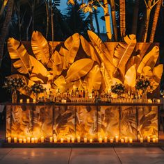 an outdoor bar decorated with candles and palm leaves