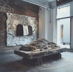 a large piece of wood sitting on top of a wooden table in front of a brick wall