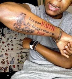 a man with a tattoo on his arm saying let your faith be bigger than you