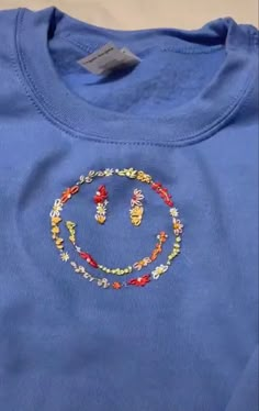 a blue shirt with a smiley face on it