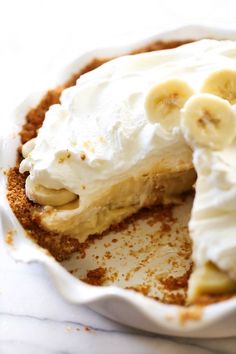 a banana cream pie with one slice cut out and the rest in the pie dish