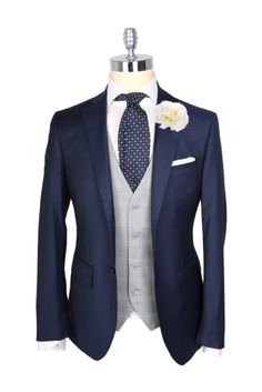 a blue suit with a white flower on the lapel