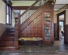 the stairs are made of wood and have bookshelves on each side, along with a bench in front of them