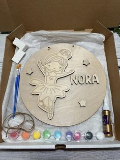 a wooden sign with the word nora on it in a box surrounded by other crafting supplies