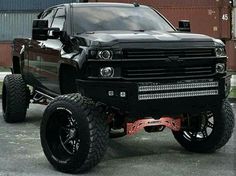 a large black truck parked in front of a building