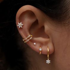 a woman's ear with three different types of piercings