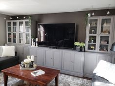 a living room filled with furniture and a flat screen tv on top of a wooden table