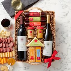 an assortment of wine, cheese and crackers in a basket