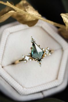 an engagement ring in a white box with gold trimmings and blue topaz