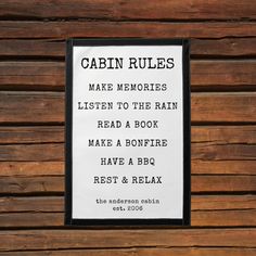 a sign on the side of a wooden building that says cabin rules make memories listen to the rain read a bonfire have a bbq rest & relax