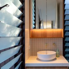 a bathroom sink sitting under a mirror next to a window