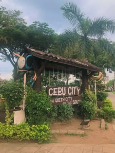 a small building with plants growing on the side and a sign that says cebu city