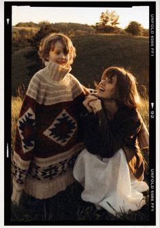 two women sitting in the grass together