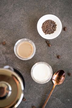 three bowls and spoons with different types of food in them on the floor next to each other