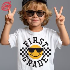 a little boy wearing sunglasses and holding up two fingers