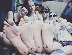 three people laying on top of each other with their feet covered in tattoos and the words love