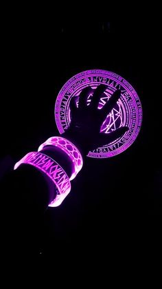 two frisbees lit up in the dark with purple designs on them and one is glowing