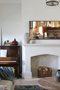 a living room filled with furniture and a piano in front of a painting on the wall