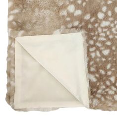 a blanket with white spots on it and a brown and white animal print area rug