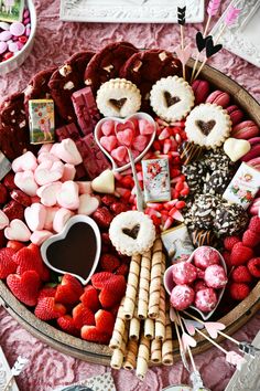 valentine's day dessert platter with strawberries, chocolates, marshmallows and heart shaped candies