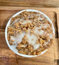 a white bowl filled with food on top of a wooden table