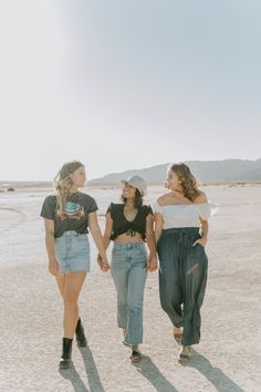 three girls walking in the desert holding hands