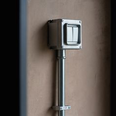 an electronic device mounted to the side of a wall next to a window with bars on it