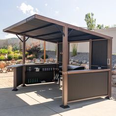 an outdoor bar is set up in the middle of a patio with rocks around it