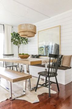 a dining room table with two chairs and a bench