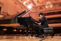 a man sitting at a piano in front of an audience