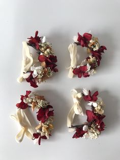 four pieces of fabric with flowers and ribbons attached to each other on a white surface