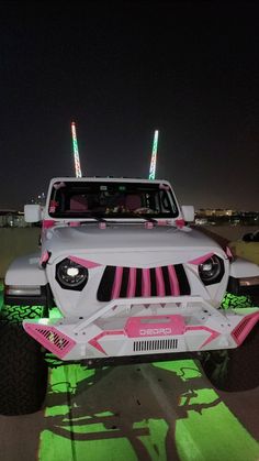 a white jeep with pink and green lights on it's hood