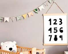 a teddy bear sitting in a crib next to a sign that reads 1237