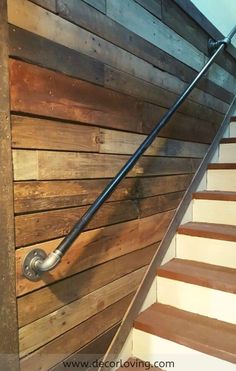 a wooden staircase with metal handrails and wood paneling